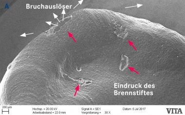 Abb.2c: Die Detailansicht im REM zeigt den Eindruck des Brennstiftes sowie den Bruchauslöser.